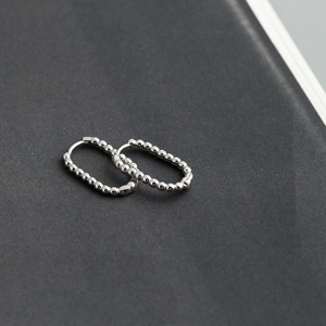 Close-up of S925 sterling silver hoop earrings with bead texture and hallmark detail