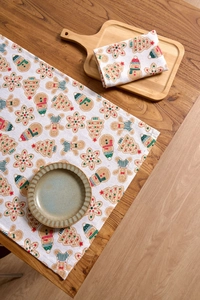 Nahaufnahme der Leinenservietten mit Lebkuchenmann und Weihnachtsmotiven auf Holztisch