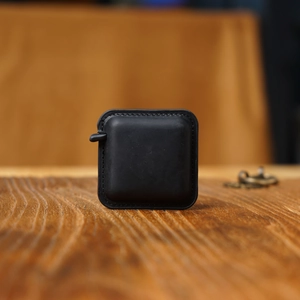 Macro shot of black crazy horse leather measuring tape case on a wooden background