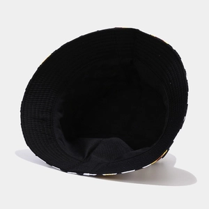 Black reversible daisy bucket hat with inner lining view and yellow flower printed brim