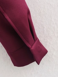 Nahaufnahme der Ärmelbündchen einer burgunderroten Jacke mit detaillierter Köperbindung