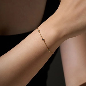 Elegant s925 silver gold bracelet with three blue heart gems on female model wrist