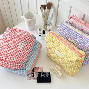 Quilted checkered cosmetic bag with bow embroidery and zipper closure in various colors