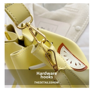 Detail of high-quality golden metal lobster clasp and smooth yellow PU leather handbag