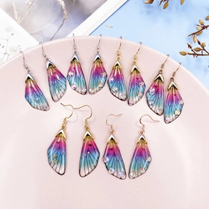 Detail of gradient butterfly wing earrings with sparkling resin finish and crystals