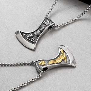 Détail de pendentifs hache viking avec gravures de loup et de corbeau en acier et or
