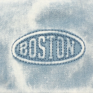 Macro detail of Boston embroidery on light blue washed denim baseball cap