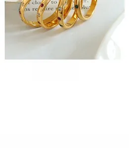 Detailed shot of gold plated hoop rings with zircon inlays on a white ceramic tray
