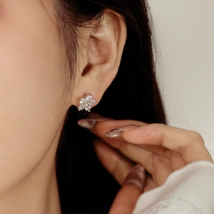 Close-up of a delicate floral S925 silver stud earring with clear zircon crystals on ear
