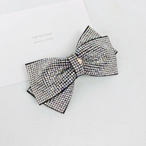 Macro detail of sparkling AB rhinestone bow hair clip with layered shimmering crystal design