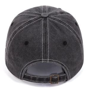 Detail of dark grey washed denim baseball cap featuring white stitching and metal buckle
