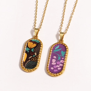 Detailed view of 14k gold plated oval pendants with intricate floral enamel patterns