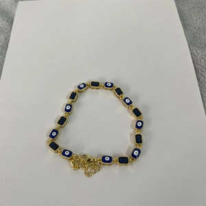 Detailed close-up of 14K gold plated evil eye bracelet with blue zircon square charms
