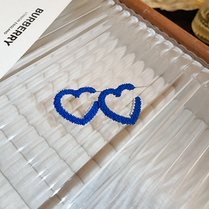 Macro detail of Klein blue velvet heart earrings with silver micro-bead inlay