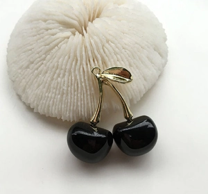 Detailed view of glossy black cherry charms with golden stems for earring DIY projects