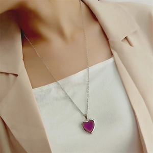 Close-up of heart-shaped thermochromic purple pendant on a stainless steel necklace