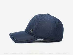 Détail d'une casquette bleue marine avec matelassage en losanges et logo W en métal