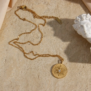 Detail of 18K gold-plated starburst pendant necklace with lobster clasp and extension chain