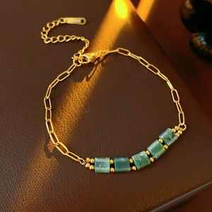 Détail macro du bracelet vintage doré avec perles carrées vert émeraude et fermoir
