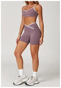Detail van yoga shorts met hoge kruislingse taille en sportbeha in mauve