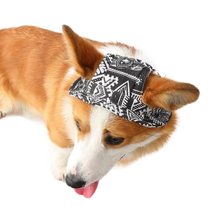 Canvas dog sun hat with black and white geometric pattern on a small Corgi puppy