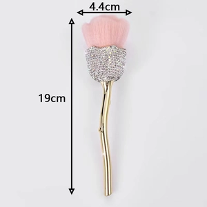 Detail of rose shape makeup brush with pink bristles, rhinestones and golden stem