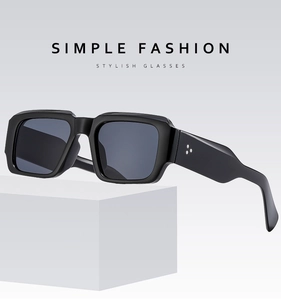 Detail of square black sunglasses with three-star metal rivets on wide temples