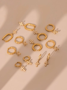 Detailed view of gold hoop earrings with sparkling zircon-studded cross pendants