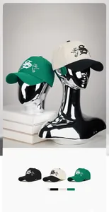 Close-up of pigeon and musical note embroidery on adjustable five-panel baseball caps