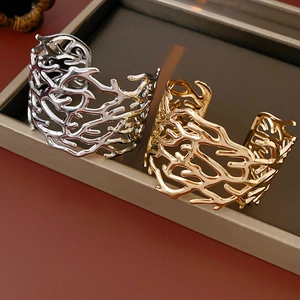 Detailed macro view of hollow cutout cuff bracelets in gold and silver finish