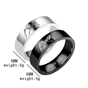 Detail view of 6mm titanium steel rings with hand-holding engraving and I Love You text