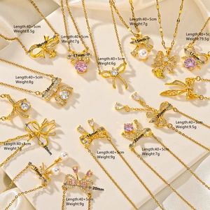 Detailed view of various golden bow necklaces with pearls and zircons on display