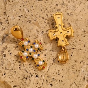 Detail of vintage 18K gold plated cross earrings with pearls and colorful gemstones