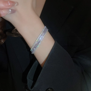 Dettaglio di bracciali tennis multistrato scintillanti in tonalità argento e lavanda