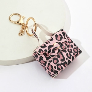 Mini leopard print handbag keychain with pink spots and golden metal clip on white stand