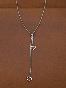 Detail of adjustable silver Y-necklace featuring dual heart pendants on a box chain