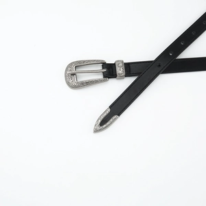 Close-up of black leather belt featuring vintage silver engraved metal buckle and tip