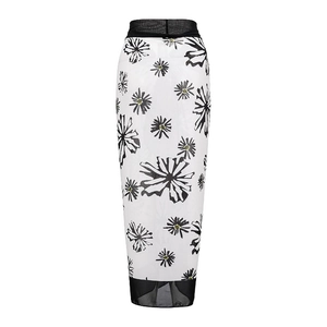 Detailed view of white floral beach cover-up skirt with black mesh trim and chiffon fabric
