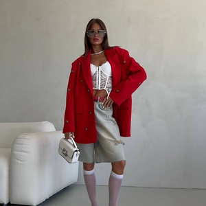 Detail of red oversized double-breasted blazer with rhinestone heart and lace top
