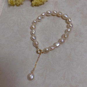 Detail of baroque freshwater pearl bracelet with 14K gold plated clasp and drop charm