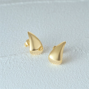 Detail of 925 sterling silver geometric C-shaped earrings with gold finish and diamonds