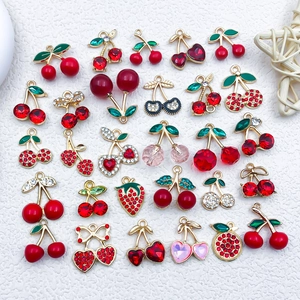 Detailed macro view of mixed cherry and strawberry charms for DIY jewelry making