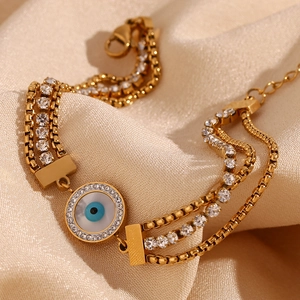 Close-up of three-layer 18K gold plated evil eye bracelet with cubic zirconia on silk