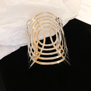 Primer plano de brazalete ancho plateado con patrón geométrico ovalado calado