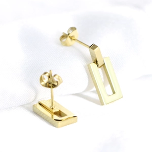Macro shot of 18K gold plated stainless steel hollow rectangle earrings on white fabric