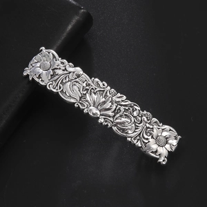 Macro shot of vintage silver metal hair clip with detailed sunflower embossment