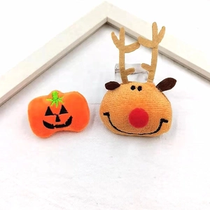 Plush Christmas reindeer and Halloween pumpkin brooch accessories on white background