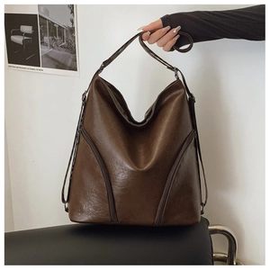 Detail of soft dark brown PU leather shoulder bag featuring textured pebble grain surface