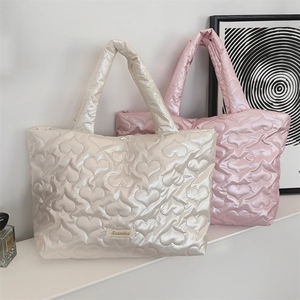 Detail of cream and pink heart-quilted lunch bags with smooth satin texture finish