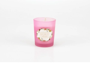 Close-up of pink frosted glass scented candle featuring ENJOY YOUR LIFE label text